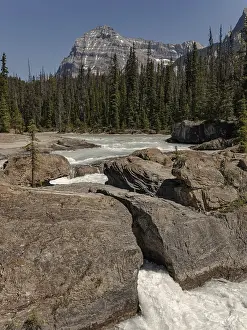 Mountainous River Scene Drucke: Rugged rocks and waterfall with a river framed by a forest