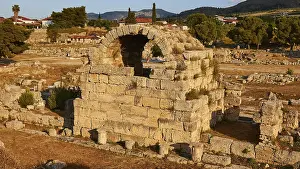 Peloponnese Archaeological Site Drucke: Ruins of an ancient structure with vegetation in the background