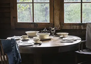 Country Style Table Setting Drucke: Rustic cabin interior with a round wooden table set with elegant tableware