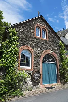 Stone Building Europe Drucke: Rustic stone house with blue Tor tor and windows