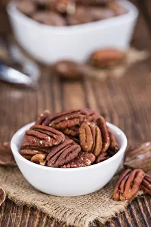 Biological Cultivation Drucke: Rustic wooden table with some Pecan Nuts (selective focus)