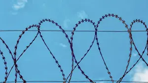 Blue Sky Background Drucke: Rusty barbed wire on blue sky background