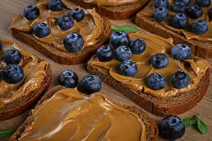 Fresh Blueberries On Rye Bread Drucke: Rye bread with peanut paste and fresh blueberries