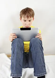 Isolated Child On White Background Drucke: Sad Kid with Tablet Computer on the White Background