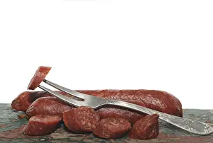 Studio Shot Of Sausage Drucke: Salami with a fork