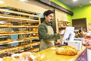 Digital Payment Transaction Drucke: Salesman using touchscreen computer to calculate the bill of a client in the counter of bakery shop