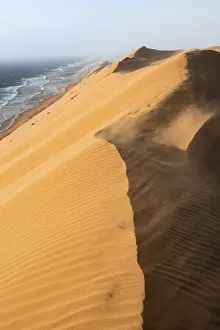 Barren Desert Landscape Photography Drucke: Sand dunes with wave patterns and sea in evening light