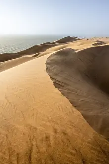 Deserted Sandy Beaches Africa Drucke: Sand dunes with wave patterns and sea in evening light