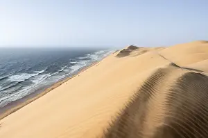 Sand Dunes Evening Light Drucke: Sand dunes with wave patterns and sea in evening light
