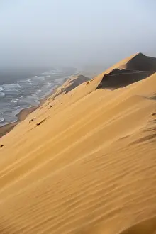 Sand Dunes Evening Light Drucke: Sand dunes with wave patterns and sea in evening light