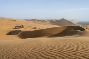 Sand Dunes Evening Light Drucke: Sand dunes with wave patterns and sea in evening light