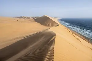 Sand Dunes Evening Light Drucke: Sand dunes with wave patterns and sea in evening light