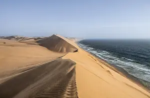 Namibia Travel Photography Drucke: Sand dunes with wave patterns and sea in evening light