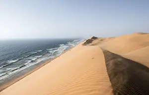 African Desert Landscapes Drucke: Sand dunes with wave patterns and sea in evening light