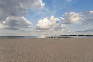 Sandy Ocean Beach Europe Drucke: Empty sandy beach and pier, cloudy sky