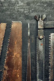 Handicraft Tools Drucke: Saws on metal surface. Rusty tools for maintenance