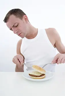 Unhealthy Eating Habits Drucke: Sceptical man with burger