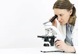 Female Scientist Drucke: Scientist using microscope in laboratory