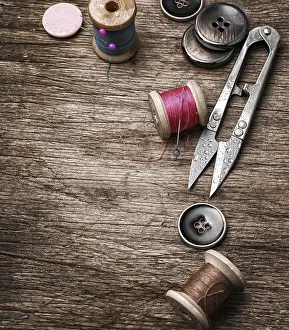 Handicraft Tools Drucke: Scissors, thread and buttons on old wooden background