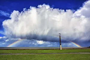 Cloudy Sky With Rainbow Colors Drucke: Seaside promenade, dramatic cloudy sky with rainbow