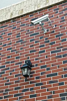 CCTV Camera Installation Drucke: Security camera and flashlight on the wall of the house