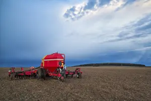 Deserted Agricultural Land Drucke: Seeding machine on the empty field before storm