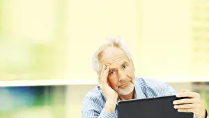Office Worker Stress Drucke: Senior, behind a laptop with a stressed expression