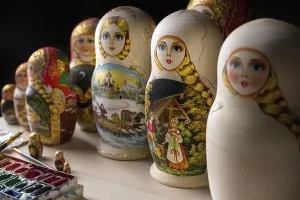 Traditional Russian Art Drucke: Set of nested dolls, russian matryoshkas on the table at dark workshop