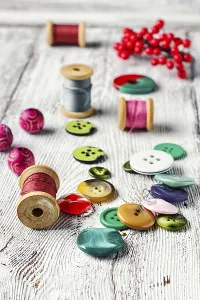 Deserted Sewing Shop Drucke: Set thread, buttons, beads on the table light vintage