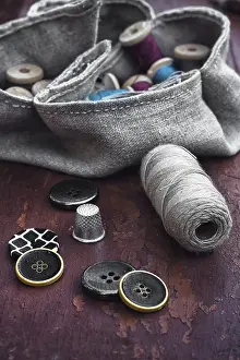 Embroidery Supplies Drucke: Set of threads and buttons on old wooden background