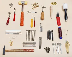 Sewing Shop Equipment Drucke: Set with various leather tools on a natural leather surface