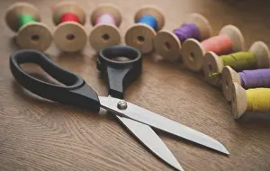 Colorful Thread Spools Drucke: Sewing concept. Scissors and colorful thread spools
