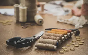 Woman At Work Drucke: Sewing concept. Scissors, threads and buttons