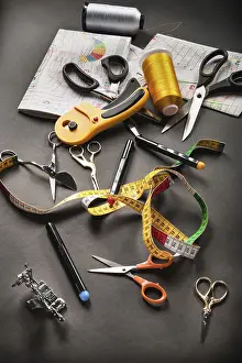 Fashionable Sewing Tools Drucke: Sewing tools thread with scissors and measuring tape on dark