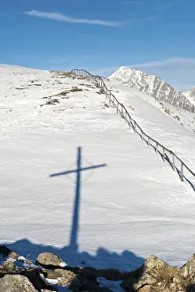 Deserted Mountain Peak Drucke: Shadow of summit cross in the snow