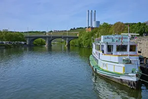Central Europe Water Body Image Drucke: A ship on a river with a bridge and chimneys in the background