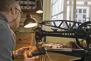 Shoemaker At Work Drucke: Shoemaker, shoemaker sews shoe to machine