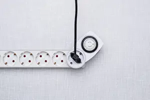 Electricity Supply Industry Drucke: Top shot of a timer in a power strip on a white Resopal panel