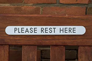 Deserted Bench Drucke: Sign: Please Rest Here, seen on a bench