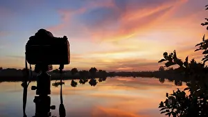 Lake Reflection Photography Drucke: Silhouette of a camera at sunset