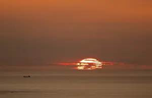 Evening Light Silhouette Drucke: Silhouette of a ship in front of the setting sun