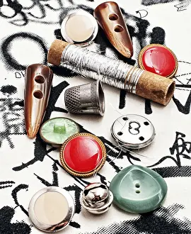 Tailor Tools Drucke: Silver bobbin of thread and a set of buttons