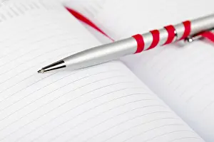 Uninhabited Office Space Decor Drucke: Silver pen on opened notebook with red string