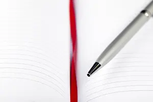 Office Supply Desk Utensils Drucke: Silver pen on opened notebook with red string
