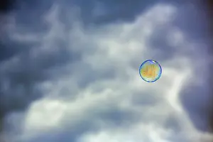 Dark Cloudy Sky Europe Drucke: Single soap bubble floating in front of dark cloudy sky