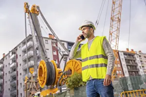 Workwear Clothing Attire Drucke: Site manager and technical engineer observing the city construction site