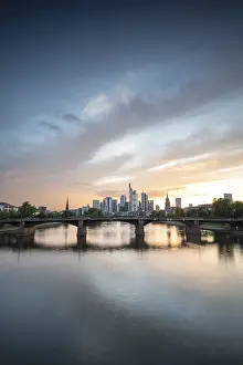 Urban Waterfront Scene Drucke: Skyline view, at sunset. On the river Main