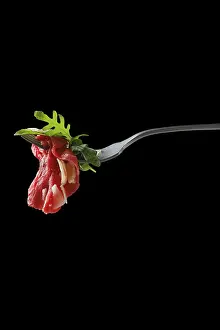 Food Photography Black Background Drucke: Slice of marbled beef carpaccio on fork over black background