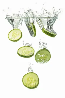 Fruit And Vegetable Still Life Drucke: Sliced cucumbers fall into the water