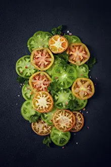 Organic Farming Drucke: Sliced green tomatoes, on a dark surface